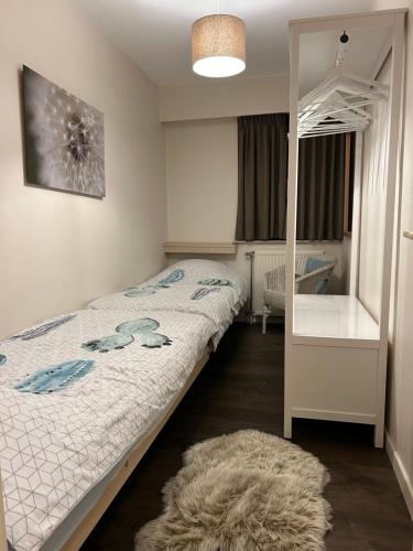 a small bedroom with a bed and a mirror at App Zeelaan A2 in Koksijde