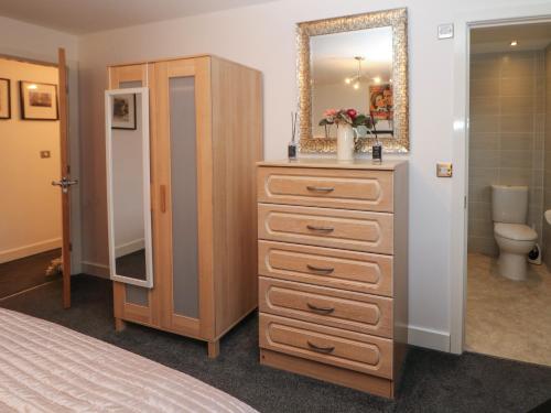 een slaapkamer met een dressoir en een spiegel bij 2 Carr Farm Close in Glossop