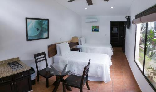 a room with two beds and a table and chairs at Room to Roam in Rivas