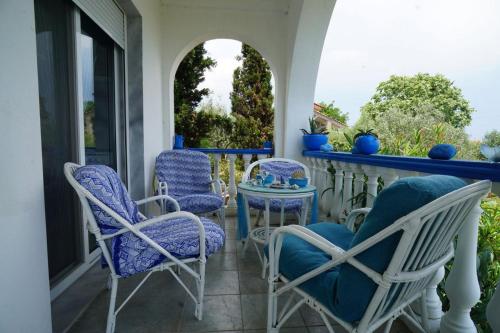 a porch with blue chairs and a table at Villa Stella-Maria in Paralía Avdhíron