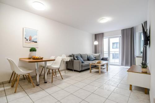 salon z kanapą i stołem w obiekcie Apartament ROSA w Kołobrzegu przy latarni w Kołobrzegu