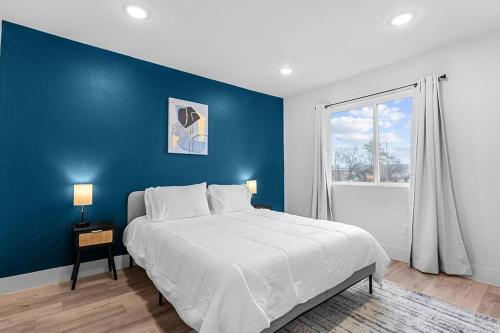 een blauwe slaapkamer met een bed en een raam bij Stylish 2 bed 1 Mile to downtown Free parking in Dallas