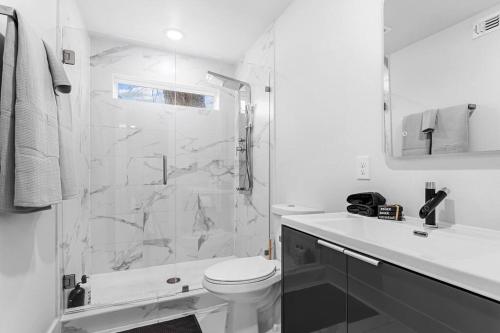 een witte badkamer met een douche en een toilet bij Stylish 2 bed 1 Mile to downtown Free parking in Dallas