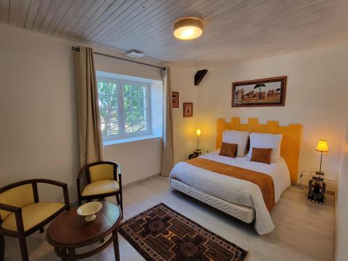 a bedroom with a bed and a table and a chair at Domaine Bassy in Saint-Gengoux-de-Scissé