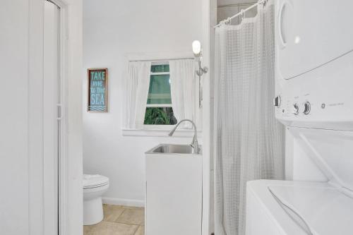 a white bathroom with a sink and a toilet at Sunny Naples - Subtropical Oasis Cottage in Naples