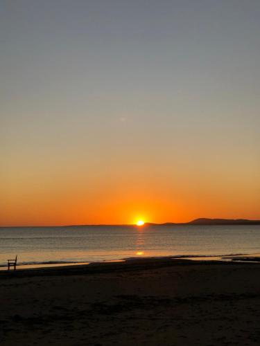 einen Sonnenuntergang über dem Meer mit einer Person am Strand in der Unterkunft I Felt The Ocean in Punta del Este