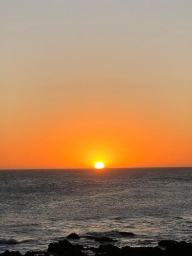 a sunset over the ocean with the sun setting at I Felt The Ocean in Punta del Este
