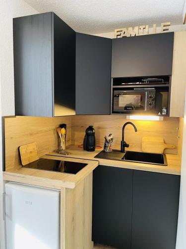 une petite cuisine avec un évier et un micro-ondes dans l'établissement Nice family cocoon in La Salle-les-Alpes, à La Salle Les Alpes