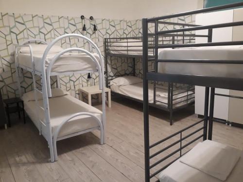 a room with four bunk beds with white seats at Balarm - Hostel and Bar in Palermo