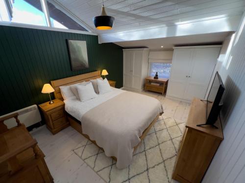 a bedroom with a bed and a flat screen tv at Green Vale Lodge, Yanwath, Ullswater in Tirril