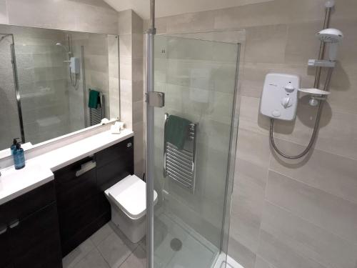 y baño con ducha, aseo y lavamanos. en Green Vale Lodge, Yanwath, Ullswater, en Tirril