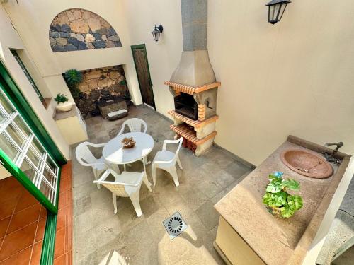 ein Wohnzimmer mit einem Tisch und einem Kamin in der Unterkunft Guanche 'Casa rural canaria' in San Miguel de Abona