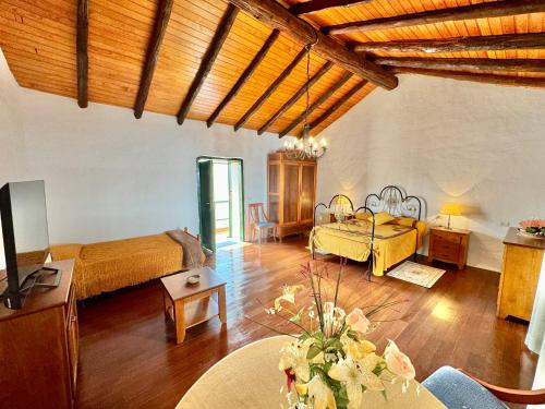 Großes Zimmer mit 2 Betten und einem Tisch in der Unterkunft Guanche 'Casa rural canaria' in San Miguel de Abona