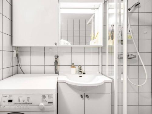 La salle de bains blanche est pourvue d'un lavabo et d'un lave-linge. dans l'établissement Fjord view by the canal - apartment, à Trondheim