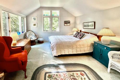 a bedroom with a bed and a couch and a chair at Walk to the Lakes in Ludlow