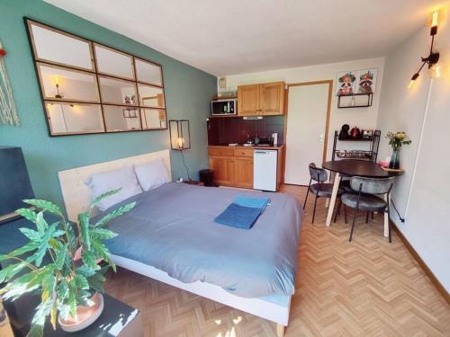 een slaapkamer met een bed en een keuken met een tafel bij Appartement ski in out 5 in Les Houches