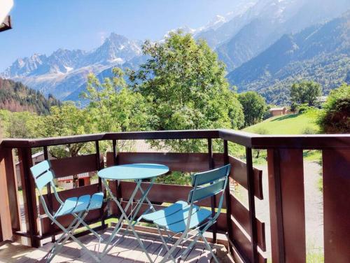 een tafel en stoelen op een balkon met uitzicht op de bergen bij Appartement ski in out 5 in Les Houches