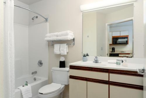 a bathroom with a toilet and a sink and a mirror at MCM Elegante Suites in Colorado Springs