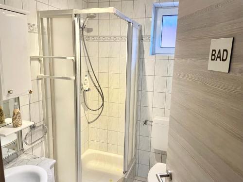 a bathroom with a shower with a bad sign on the wall at Casa Giulia 2 Zimmer, Küche, Bad, WLAN, Parkplatz in Gleiberg