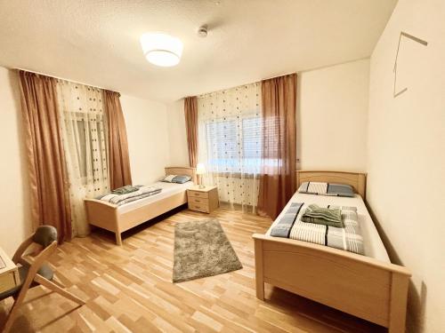 Habitación con 2 camas y una silla. en Casa Giulia 2 Zimmer, Küche, Bad, WLAN, Parkplatz en Gleiberg