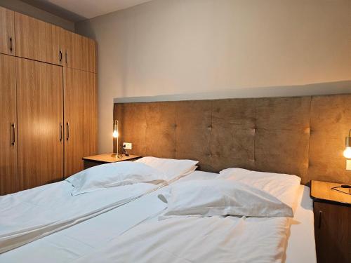 a bedroom with two beds with white pillows at Vila Predeal Holidays in Predeal