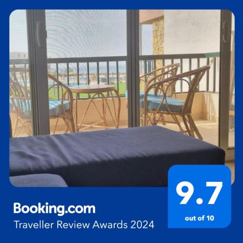 a room with a bed and chairs on a balcony at Modern Front Seaview chalet El Sokhna in Ain Sokhna
