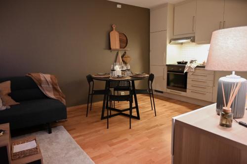 a living room with a table and a kitchen at Hotel feeling in the center of Trondheim in Trondheim