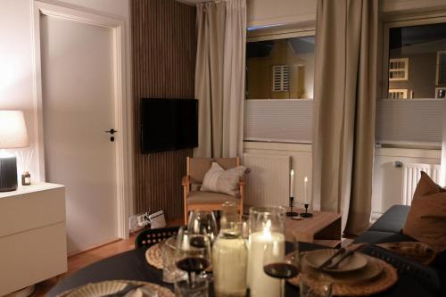 una sala de estar con una mesa con copas de vino. en Hotel feeling in the center of Trondheim, en Trondheim