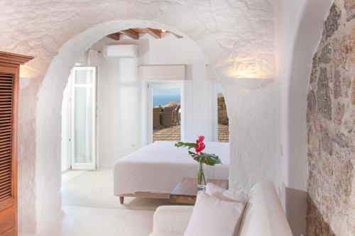 a bedroom in a villa with a bed and a window at Aegean Stones in Agios Ioannis Mykonos