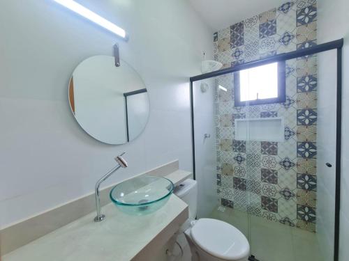 La salle de bains est pourvue d'un lavabo, de toilettes et d'un miroir. dans l'établissement Flat aruan 2, à Caraguatatuba