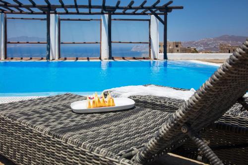 a pool with a table with a plate of matches at Aegean Stones in Agios Ioannis Mykonos