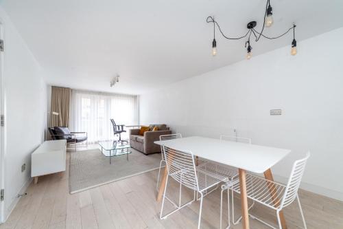 a kitchen and living room with a white table and chairs at Two Bedroom Belgravia Charm in London