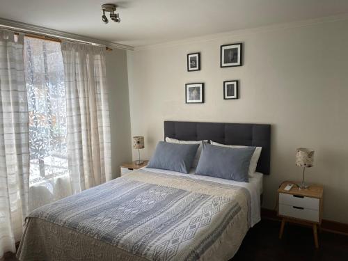 um quarto com uma cama com almofadas azuis e uma janela em Departamento en el corazón de Providencia em Santiago
