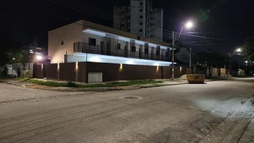 une rue vide devant un bâtiment la nuit dans l'établissement Flat aruan 2, à Caraguatatuba