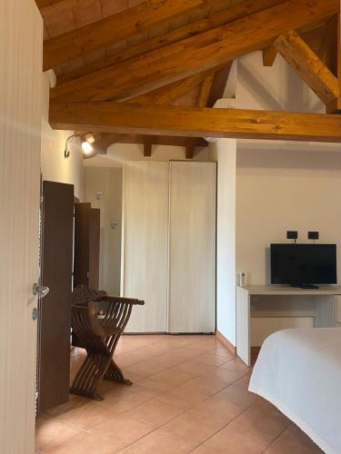 Habitación con cama, mesa y TV. en B&B Molinetto, en Piacenza