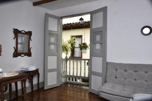 a living room with a door open to a balcony at La Estancia Hotel Boutique in Salamina