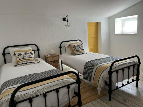 a bedroom with two beds and a window at Cantinho da Villa in Portel