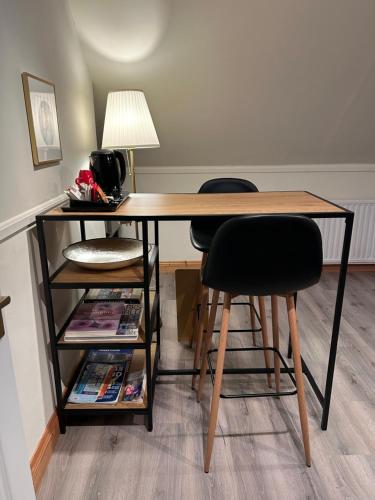 a desk with two chairs and a table with a lamp at The Loft @ Kildare Village in Kildare
