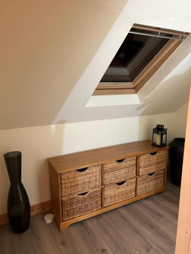 a room with a wooden dresser in a attic at The Loft @ Kildare Village in Kildare