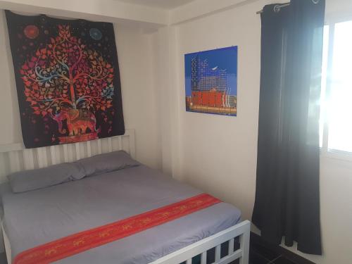 a small bedroom with a bed and two pictures on the wall at BTL Sunny in Bang O
