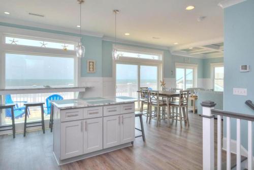 a kitchen and dining room with a view of the ocean at Latitude Adjustment in Oak Island