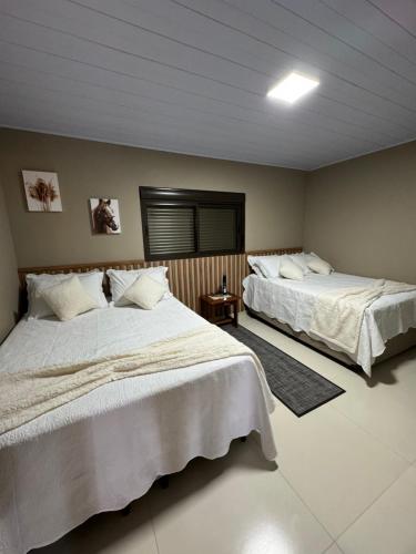 um quarto com 2 camas e uma janela em Cabana Santo Reffúgio em Urubici