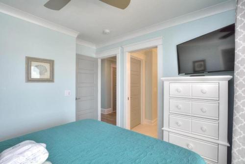 a bedroom with a bed and a flat screen tv at Latitude Adjustment in Oak Island