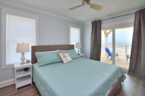a bedroom with a bed with a view of the ocean at Latitude Adjustment in Oak Island
