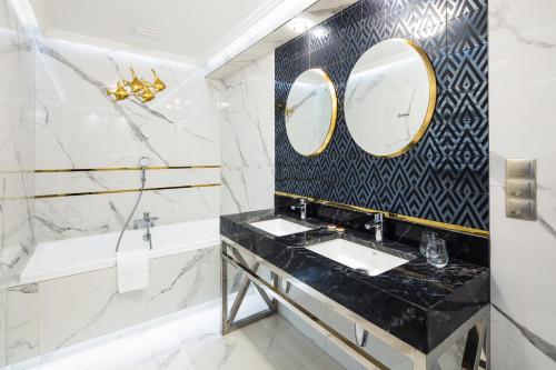 a bathroom with two sinks and a mirror at Hotel Royal Baltic 4* Luxury Boutique in Ustka