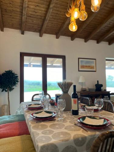 a dining room table with glasses and a bottle of wine at Cantinho da Villa in Portel