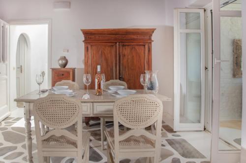a dining room with a wooden table and chairs at Aegean Stones in Agios Ioannis Mykonos