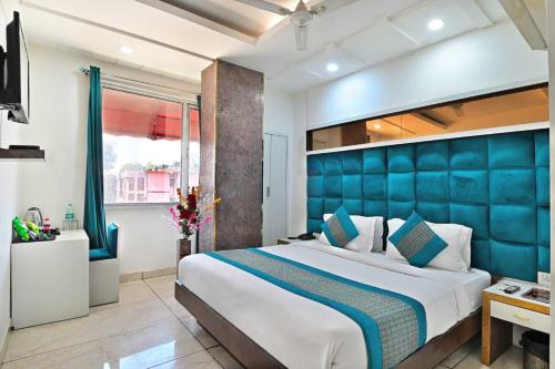 a bedroom with a large bed with a blue headboard at The New Lord Krishna @ New Delhi Railway station in New Delhi