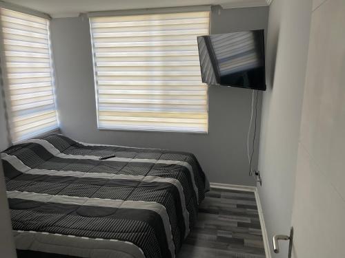 um quarto com 2 camas e uma televisão de ecrã plano em Depto portal del sol em Arica