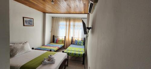 a small bedroom with two beds and a window at Luna verde hotel in Neiva